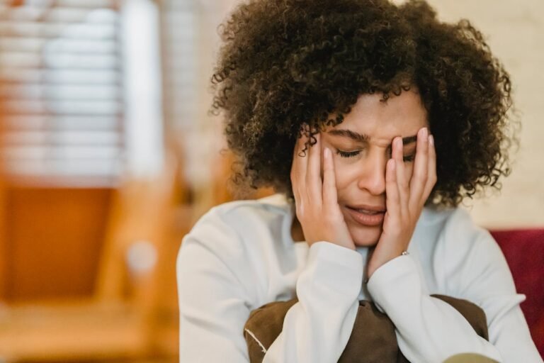 Frustrated black woman sitting in room